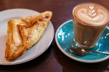 Latte art coffee with croissant so delicious on wooden table 