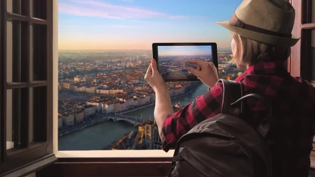 tourist taking picture of lyon skyline at sunrise,woman takes photo of city using tablet high view