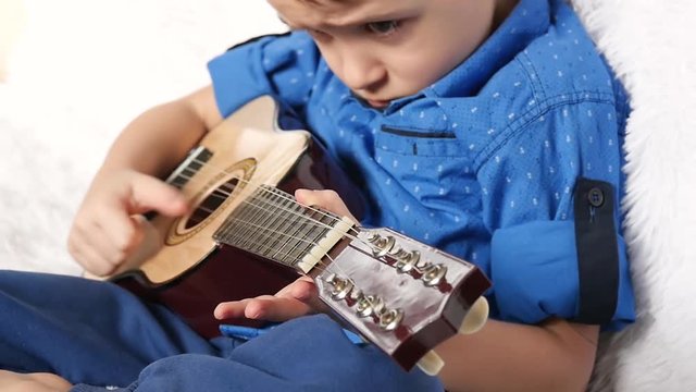 A child plays a broken guitar