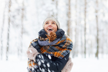 Waist up portrait of beautiful young woman in winter forest having fun and enjoying snow, copy space