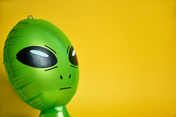 green alien looks,yellow background