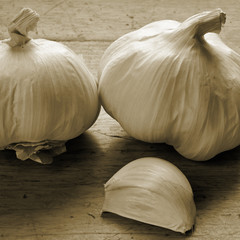 Garlic on wooden surface. Close up monochrome square shape image.
