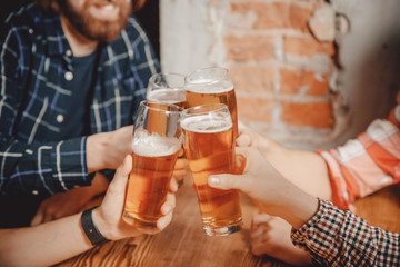 People, young guys in pub, beer restaurant, happy friends. Concept meeting, weekend, clink of glasses at bar