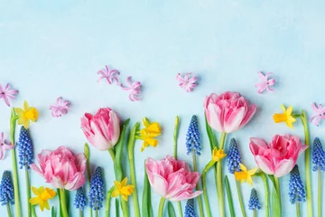 Tuinposter Creative composition of beautiful spring flowers on pastel table top view. Greeting card for International Women Day. Flat lay. © juliasudnitskaya