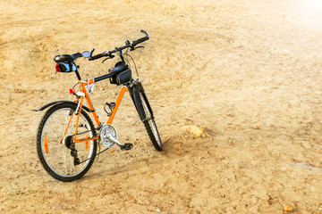 Fototapeta premium The bike is on the ground. Riding a bike through the mountains. Traveling by bike through the desert. Sport and healthy lifestyle.