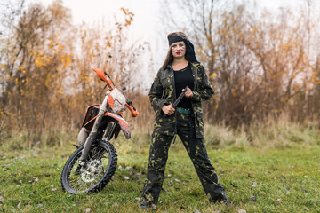 Woman warrior in camouflage form posing outdoors