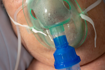 Old Man in bed with oxygen mask in hospital