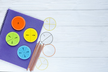 Colorful bright fractions in mathematics on white wooden table. interesting math for kids children. Education, back to school concept. top view with copy space