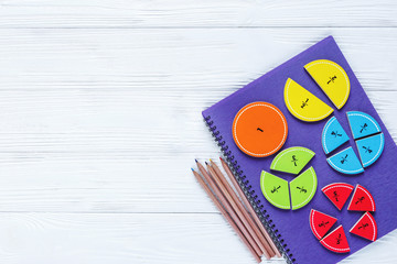 Colorful bright fractions in mathematics on white wooden table. interesting math for kids children. Education, back to school concept. top view with copy space