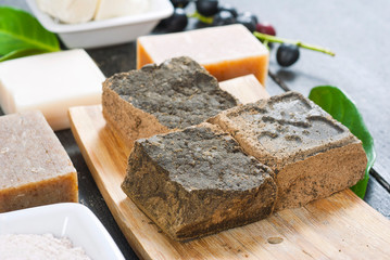 cosmetic clay, soaps, henna blocks, raw shea butter on black wood table
