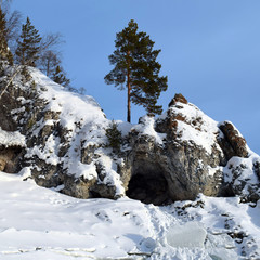 Cave in the rock. Winter landscape.  Snow in mountains.