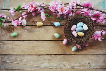 Cherry blossom Artificial flowers and easter egg in nest on vintage wooden background with copy space.