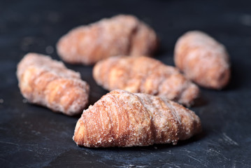 group of sugary croissants on dark blue textured background