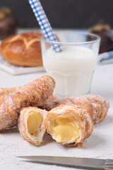 glass of milk with sugary croissants and sweet rolls on white textured background
