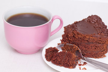 Delicious chocolate cake on plate with pink cup of coffee on table on light background