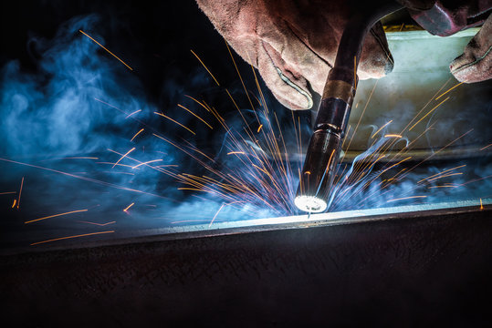 Industrial welder welding fabricated construction in factory, Welding process by Flux Core Welding, FCAW