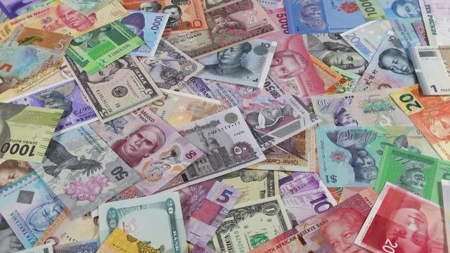 World currencies notes heap slow rotating. World money, economy. Low angle. 4K stock video footage
