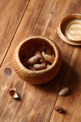 Raw Almond in a little basket, on wooden background.