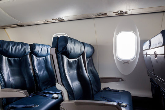 Armchairs in passenger cabin, with safety belts Aircraft seats and window.
