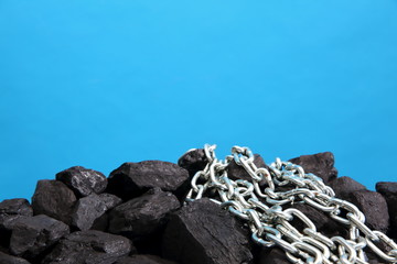 Chain lying on hard coal as attachment of humanity to this raw material.