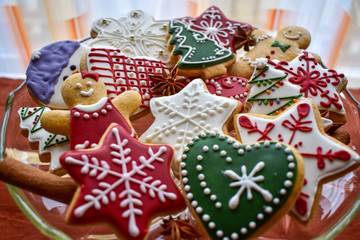 Traditionally decorated Christmas gingerbread cookies on a blass bowl