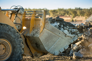 Close up view of a bulldozer shovel moving some rocks at a mine in NSW, Australia