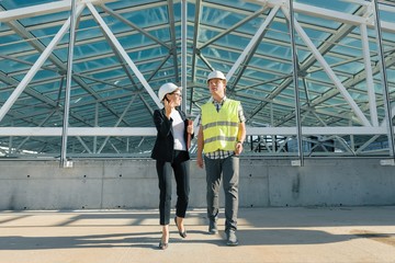Woman engineer and man builder at construction site. Building, development, teamwork and people...