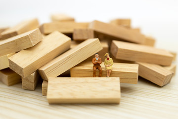 Miniature people : Businessman sitting on wooden , image use for business concept.