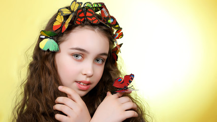 Portrait of a beautiful girl with butterflies on her hair