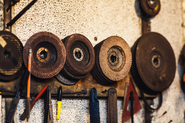 abrasive grinding wheels hang on the wall in the workshop.
