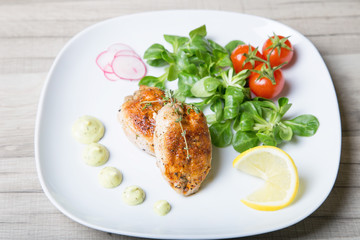 Fried quails, with salad leaves corn, cherry, radish and lemon. Selective focus, close-up.