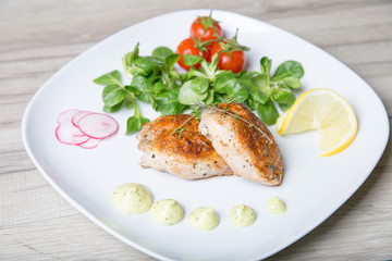 Fried quails, with salad leaves corn, cherry, radish and lemon. Selective focus, close-up.