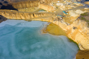Aerial view of opencast mining quarry with lots of machinery. Industrial place view from above....
