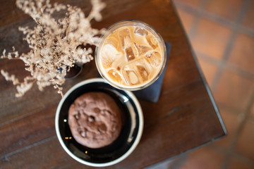 Top View of Ice Latte Coffee in a glass  with Chocolate Chip Cookie on a Wooden Table