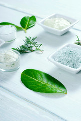 beauty products, cosmetic clay powder, bath salt and cream on white wooden table background