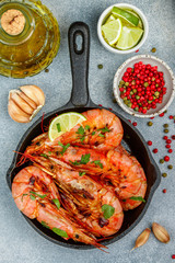 Fried king prawns with garlic, pepper, lime and parsley (cilantro). Large shrimp. Langoustine. Selective focus