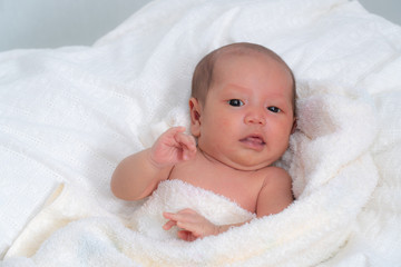 Sweet baby in a white towel after bath. Healthcare, pediatrics.