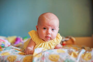 A small child confidently holds his head. The first skills of the child. Child development by months. The first month of life a healthy baby.