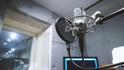 Studio microphone or mic for recording for vocal singer or commercial announcer with shock mount and pop filter on professional tripod in acoustic foam room for best sound and mix process