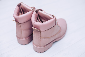 Beautiful women's winter pink boots on the rear on a white wooden background