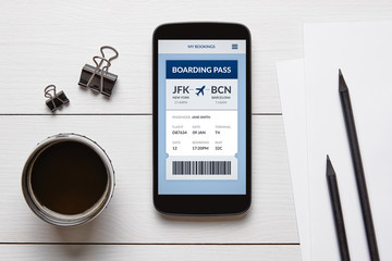 Boarding pass concept on smart phone screen with office objects