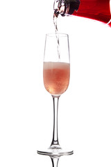 pouring pink wine into glass, isolated on white background