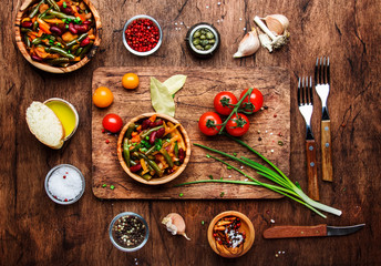 Green beans with roots, vegetables, mushrooms, spices and tomatoes, vegan bowls. Food cooking background, vintage wooden rustic table. View from above