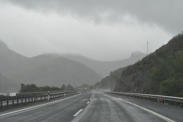 Rainy highway sorrounded by mountains