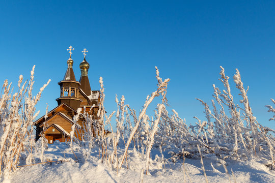 Church in winter with bushes and snow. Norilsk