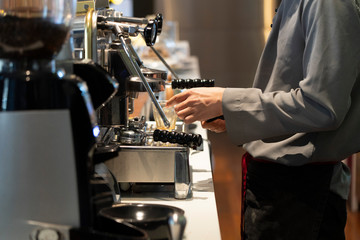 View of barista in the cafe making a cup of coffee with the coffee brewing machinery