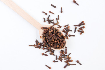 Cloves in wooden spoon isolated on white background. Closeup.