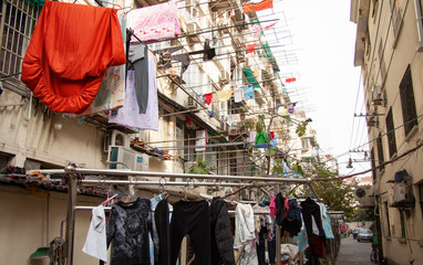 Windows and balconies in backyard of a residential building with clothes hanging at windows in rural modern Beijing, China.