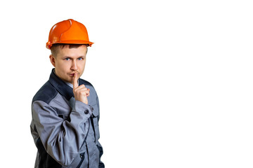 Builder in an orange helmet shows a hand gesture "do not yell." isolated