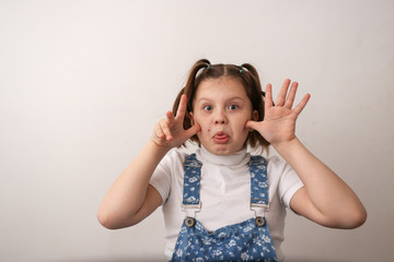 funny girl child builds faces, shows tongue